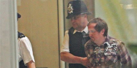 Policie odvádá Jonnieho Marblese poté, co zaútoil na Ruperta Murdocha (19. ervence 2011) 