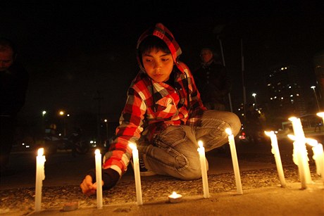 Dítě zapaluje svíčky před budovou televize TVN po pádu letadla v Tichém oceánu.