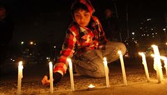 Dítě zapaluje svíčky před budovou televize TVN po pádu letadla v Tichém oceánu. | na serveru Lidovky.cz | aktuální zprávy