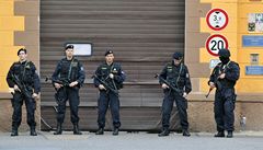 Bránu hlídají ozbrojení policisté.