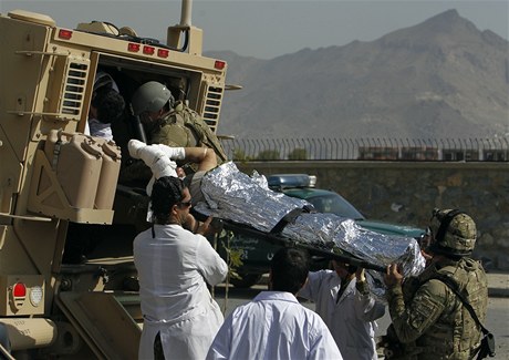 Zdravotníci odváejí vojáka, který byl zrann v Kábulu pi útoku na konvoj NATO