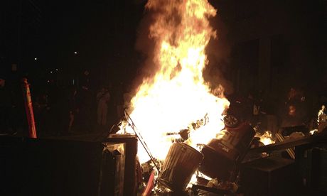 V noci se protest v centru Oaklandu vystupoval. Uprosted jedné z ulic zaloili demonstranti hranici z odpadkových ko, kterou zapálili.