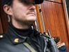 Ozbrojený policista hlídkuje ped budovou soudu