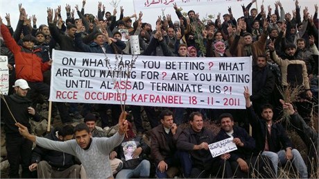 Protestanti drí transparent pi demonstraci proti syrskému prezidentu Asadovi.