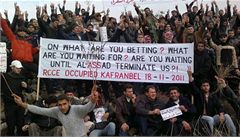 Protestanti drí transparent pi demonstraci proti syrskému prezidentu Asadovi.