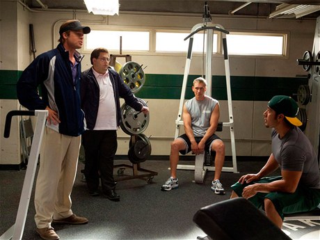 Nesourodá dvojka. Billy Beane (Brad Pitt) a Peter Brand (Jonah Hill, druhý zleva) zasvěcují hráče do svých kouzel. 