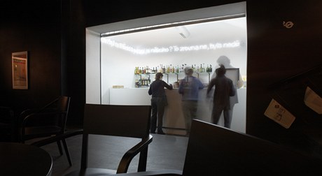 Bar, bílý ostrov uvnitř černého foyer.
