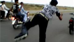 Pákistánec jezdí za motorkou bez �idi�e na kole�kových bruslích.