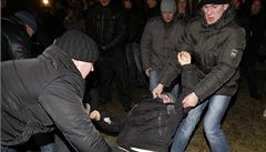 Blorutí policisté v civilu zatýkají demonstrující obany (ilustraní).