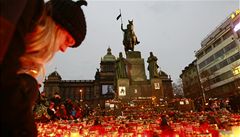 Lidé na Václavské náměstí stále přinášejí nové svíčky a ty starší obnovují.  