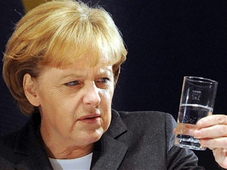 Angela Merkelová zírá na sklenici vody.
