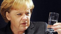 Angela Merkelová zírá na sklenici vody.