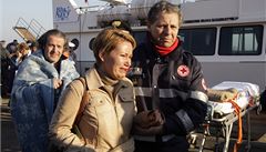 Záchraná�i odvád�jí jednu z �en.