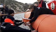 �lenové pob�e�ní hlídky si p�edávají �ernou sk�í�ku z potáp�jící se lodi.