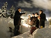 Úspný stavitelský den zapíjí lidé horkými nápoji na pozadí rozsvíceného Davosu.