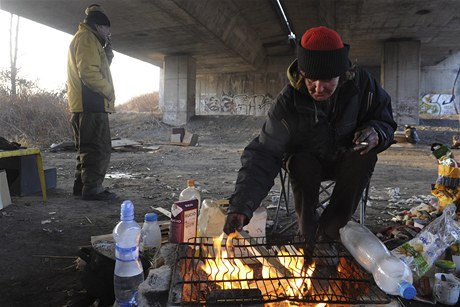 Bezdomovci se zahívají alespo u ohn. 