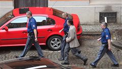 Ingr v doprovodu policist� opou�tí budovu soudu..