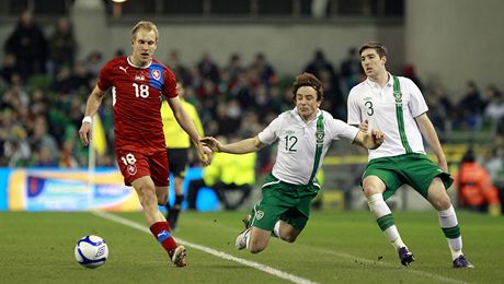 eský fotbalista Daniel Kolá utíká v zápase proti Irsku Stephehu Huntovi (uprosted)  