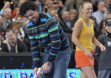 Golfová jednička Rory McIlroy si v New Yorku zahrál tenis proti Šarapovové. Raketu mu předala jeho přítelkyně Caroline Wozniacká (vpravo) 