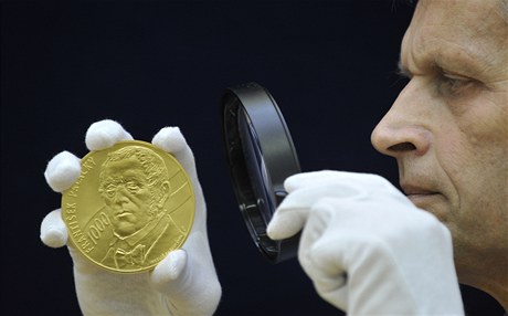 Odborník zkoumá zlatou investiní medaili s motivem Frantika Palackého.