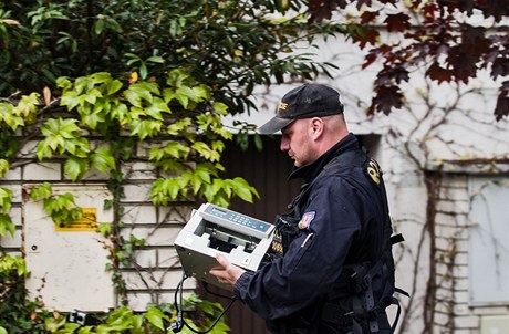 Policisté pináejí k domu Davida Ratha poítaku bankovek. 