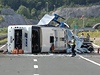 Havarovaný autobus leí na boku, policie zkoumá okolí nehody.