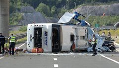 Havarovaný autobus leží na boku, policie zkoumá okolí nehody.