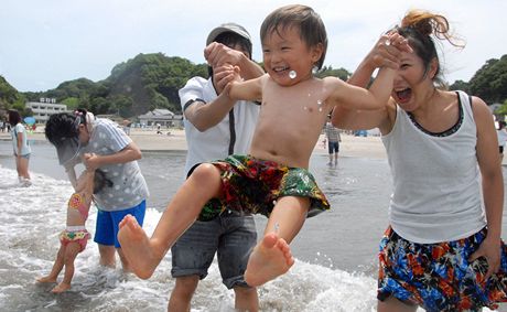 Rodiny s dtmi si hrají na plái nedaleko Fukuimy.