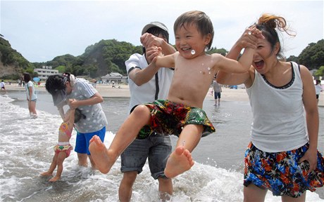 Rodiny s dtmi si hrají na plái nedaleko Fukuimy.