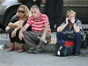 Cestující sedí na silnici krátce po výbuchu autobusu u letit v Burgasu