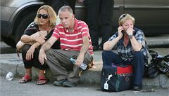 Cestující sedí na silnici krátce po výbuchu autobusu u letit v Burgasu