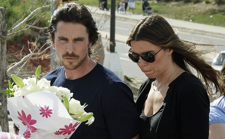 Herec Christian Bale s manelkou pináí kvtiny na pietní místo v centru Aurory.