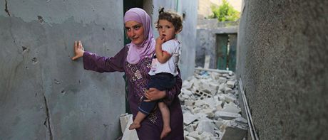Matka s díttem prochází znienou tvrtí v Aleppu