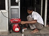 Prodava ped obchodem v Dillí spravuje rozbitý generátor.