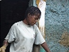 Haiťanka vyklízí svůj zabahněný dům.