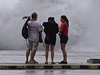 Lidé na havanském bulváru El Malecon pozorují vlny.