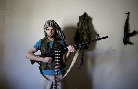 Syrský rebel Amar Aldírání, který zbhl z vládních ozbrojených sil, pózuje ped domem v Alpeppu, kde se ostatními bojovníky chystají k útoku proti Asadovým jednotkám.  
