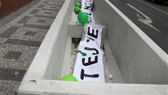 P�es ulici zav�ený plakát s nápisem "Vítejte v Truhlíkolandu" n�kdo sundal a vhodil do betonových truhlík� na chodníku.