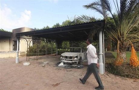 Mu prochází kolem ohoelého auta u americké ambasády v Benghází, kde dolo k raketovému útoku.