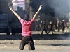 Symbol vítzství ukazuje demontrant na zásahovou jednotku v ulici vedoucí k americkému velvyslanectví  Káhie.