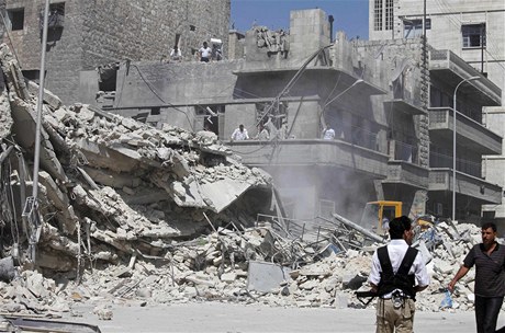 Civilisté a písluníci Svobodné syrské armády u zboeného domu po náletu syrské armády