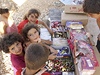 Dti z uprchlického tábora si kupují sladkosti od jiného obyvatele tábora, který si ped svým stanem otevel mení "obchdek".