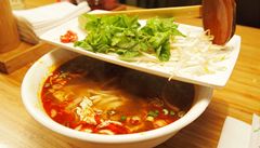 Vietnamská polévka pho, doplnná limetkou, chilli paprikami, bambusovými výhonky a erstvými bylinkami.
