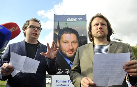 Dokumentaristé Vít Klusák (vlevo) a Filip Remunda (vpravo) pimalovali 11. íjna v Praze na volebním billboardu ODS tykadla senátnímu kandidátovi strany Tomái Töpferovi. 