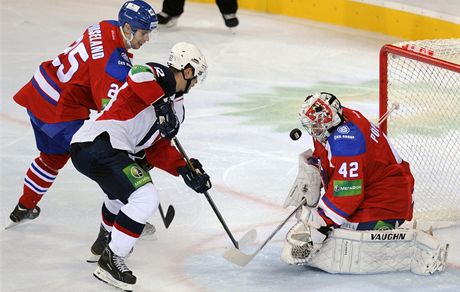 Michal Vondrka z HC Slovan Bratislava stílí gól. Vpravo branká Tomá Pöpperle z týmu Lev Praha