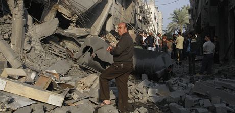 Palestinci u domu, který zniily izraelské rakety