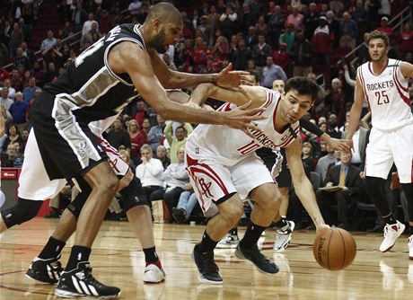 Carlos Delfino z Houston Rockets se snží dostat míč okolo hráče San Antonio Spurs Tima Duncana