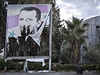 Písluník Svobodné syrské armády se modlí u streného portrétu diktátora Baára Asada.