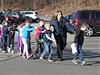 Policistka odvádí áky základní koly Sandy Hook do bezpeí.