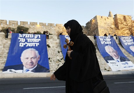 Provoslavná kesanka míjí banery s podobiznnou izraelského premiéra na hradbách starého msta v Jeruzalém. 